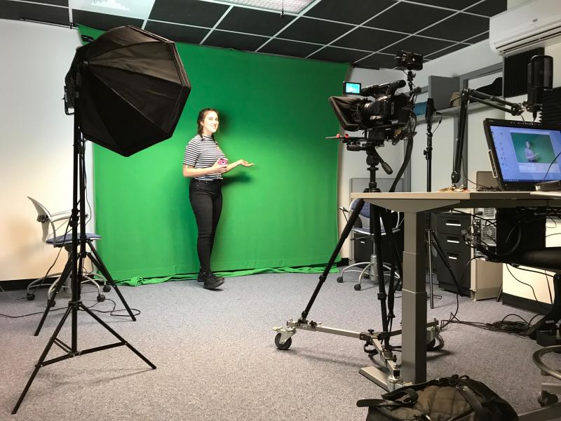 学生站在数字媒体实验室的绿色屏幕前